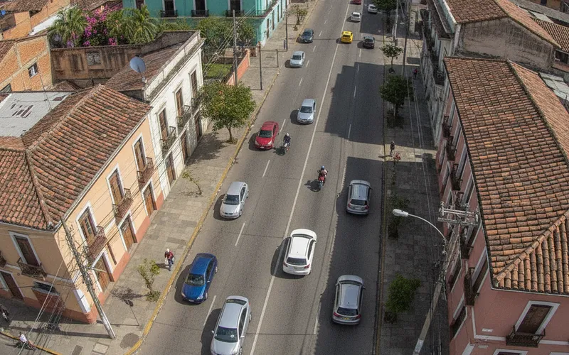 Cámara sobre una calle con carros y motos